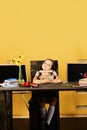 Girl sits at desk with colorful stationery, flowers and fruit Royalty Free Stock Photo