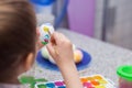 The girl sits in kitchen and paints with an egg brush for Easter, a look from the first person Royalty Free Stock Photo