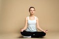 A girl sits in a lotus position and meditates with her eyes closed. Zen practice, breath technique. Consideration and praying