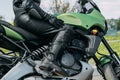 A girl sits on a motorcycle in protective moto overalls, safety equipment Royalty Free Stock Photo