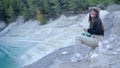 Girl sits in nature and drums in air with utensils, slomo side view