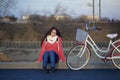 The girl sits next to a parked bike. Rest on the spring cycle Royalty Free Stock Photo