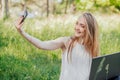 girl sits outdoors and works at a laptop. makes a selfie on the phone. freelance. selfeducation. the concept of remote