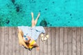 Girl sits on the pier near the parked boats on the Mediterranean coast. Vacation and travel concept