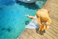 girl sits on the pier near the parked boats on the Mediterranean coast. Vacation and travel concept