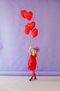 Beautiful girl sits with red heart balloons Royalty Free Stock Photo
