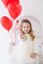 Little girl sits with red heart balloons Royalty Free Stock Photo