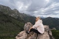 A girl sits on a rock in the Polish Tatra Mountains in stormy weather Royalty Free Stock Photo