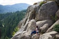 The girl sits on the rocks