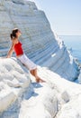 A girl sits on a slope of white cliff called 