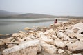 A girl sits on a stone by the lake like a mermaid. Royalty Free Stock Photo