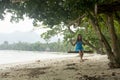 A girl sits on a swing on a tropical beach. Royalty Free Stock Photo