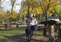 a girl sits at a table in an autumn park, headphones are on her head Royalty Free Stock Photo