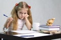 The girl writes on a piece of paper sitting at the table in the image of the writer Royalty Free Stock Photo