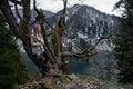 Girl sits on a tree and meditates near lake Ritsa in Abkhazia Royalty Free Stock Photo