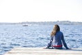 Girl sitting alone on dock by lake Royalty Free Stock Photo
