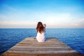 Girl sitting alone and hand holding camera on a the wooden bridge.