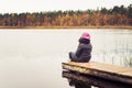 Girl sitting alone on a peaceful footbridge in the middle of nowhere