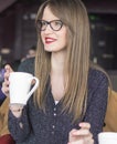 The girl is sitting in a bar and drinking tea