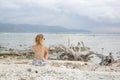 Girl sitting on the beach, looking at the horizon Royalty Free Stock Photo