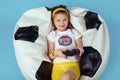 Girl sitting on bean bag chair, holding joystick and playing video game Royalty Free Stock Photo