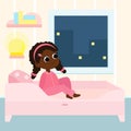 The girl is sitting on the bed in pajamas. This is a children\'s bedroom in pastel colors. The child is smiling happily.