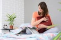 Girl sitting on the bed and reading a newspaper with job advertisements