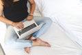 Girl sitting on bed using a laptop Royalty Free Stock Photo