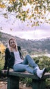 Girl sitting on a bench in the autumn park near the lake Royalty Free Stock Photo