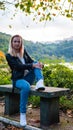 girl sitting on a bench in the autumn park near the lake Royalty Free Stock Photo