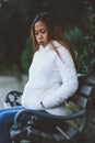 Girl sitting on bench in the city park in cold weather Royalty Free Stock Photo