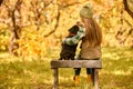 A girl sitting on the bench with her dog in the park Royalty Free Stock Photo