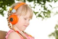 Girl sitting on bench in park and listening language audio course