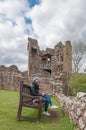 Girl sitting on a bench in the ruins of Urquhart Castle, Loch Ness, Scotland Royalty Free Stock Photo