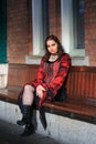 Girl sitting on bench wearing red dress Royalty Free Stock Photo
