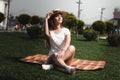 A Girl Is Sitting On The Blanket On The Grass In The Park With Crossed Legs. Royalty Free Stock Photo