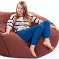 Girl sitting on a braun beanbag chair.