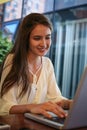 Girl sitting at cafe text mails.