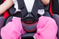 Girl sitting at carseat and fasten seat belt Royalty Free Stock Photo