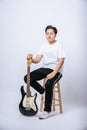 Girl sitting on a chair and holding a guitar Royalty Free Stock Photo