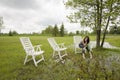 Girl Sitting on Chair in Rain Soaked Yard Royalty Free Stock Photo