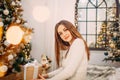 Girl sitting in Christmas decorated bedroom and holding a gift box Royalty Free Stock Photo