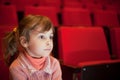 Girl sitting at cinema, steadfastly looking Royalty Free Stock Photo