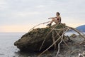 Girl sitting on a cliff and looking water of Black sea