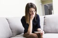 Girl sitting on a couch at home while reading the results of her recent pregnancy test Royalty Free Stock Photo