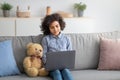 Girl sitting on the couch and using her laptop Royalty Free Stock Photo