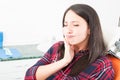 Girl sitting in dentist chair making tooth pain gesture