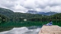 Girl sitting on the dock of the black lake in the Durmitor national Park. Montenegro. Royalty Free Stock Photo