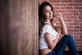 Girl sitting down against wooden Royalty Free Stock Photo