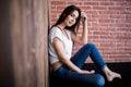 Girl sitting down against wooden Royalty Free Stock Photo